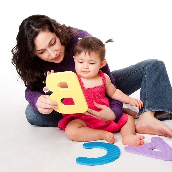 a teacher helping a child learn the alphabet