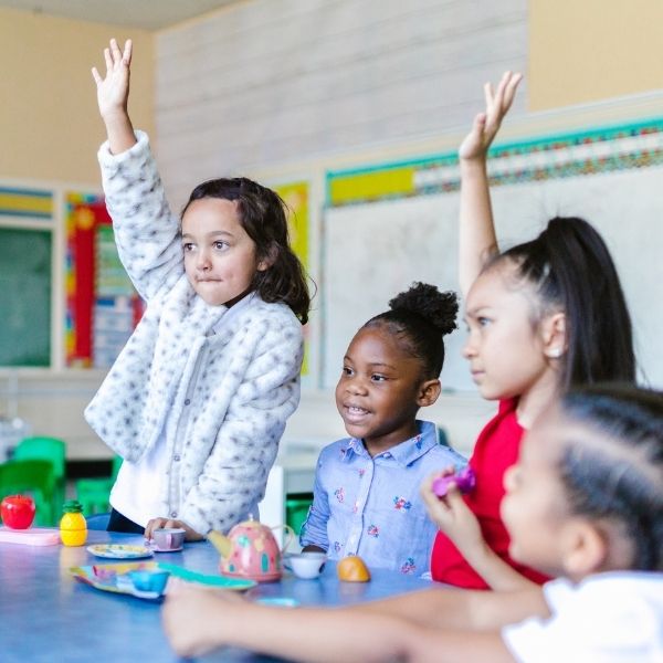 kindergarteners raising their hands